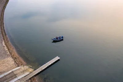 Aerial shot of a small boat near a pier on a calm Minnesota lake, creating a peaceful scene.